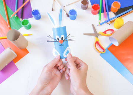 step 4. DIY paper rabbit from a roll of toilet paper. Easy craft for kids on white background,...
