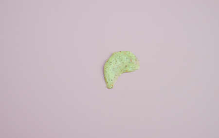 Sample of natural green scrub on a pink background. Peeling cream with microcapsules. Smear of apple or coffee scrubの写真素材