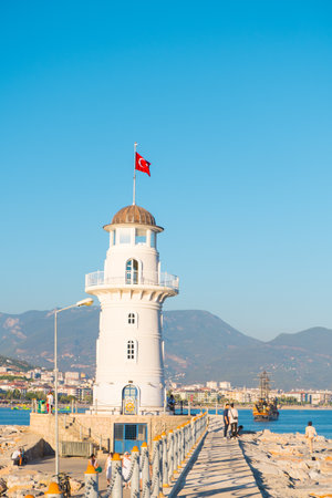 Alanya, Turkey - August 29, 2022: Old lighthouse and pleasure boat in the port of the Turkish city of Alanya.のeditorial素材