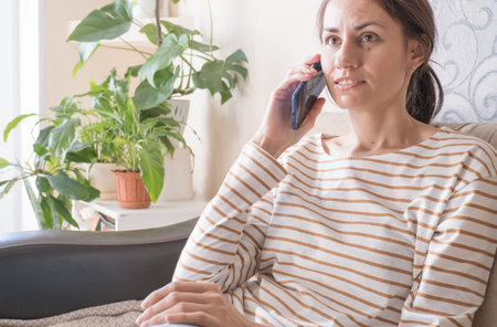 Feminine gossip while relaxing on couchの写真素材