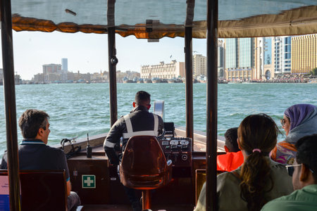 Dubai, United Arab Emirates - February 14, 2023: Traditional wooden tourist boats, abra water taxis and modern sailboats use Dubai Creek in Deira, the historic district of Dubai in the United Arab Emiratesのeditorial素材