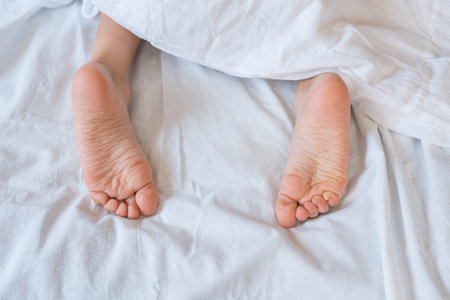Close-up of a children's legs on a white blanket.