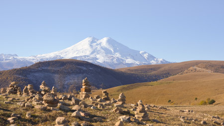 The Garden of Stones with Mount Elbrus as a backdrop. Pyramids of stones. Pebble tower balance harmony stones arrangement. Spa therapy summer travel vacation.の写真素材
