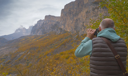 Male nature photographer takes pictures in the mountains