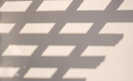 Minimalist abstract light beige background for product presentation with light reflections and abstract shadow on the wallの写真素材