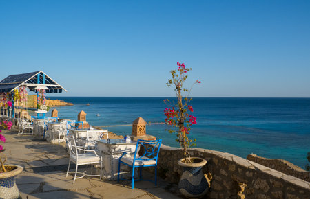 Beautiful white and blue street cafe on the seashore.の写真素材