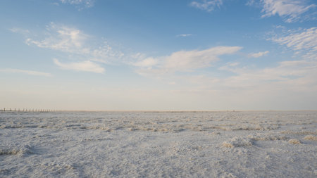 Landscape of a salt lake with a flat white surface under the light of a blue sky. Lake Baskunchak in...
