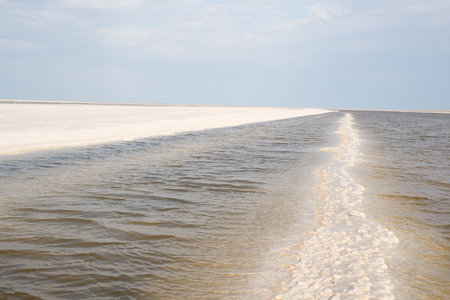 Landscape of a salt lake with a flat white surface under the light of a blue sky. Lake Baskunchak in...