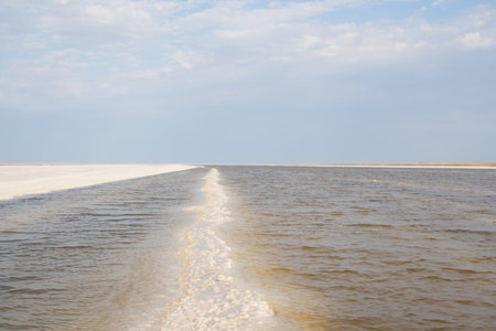 Landscape of a salt lake with a flat white surface under the light of a blue sky. Lake Baskunchak in the Astrakhan region of Russiaの写真素材