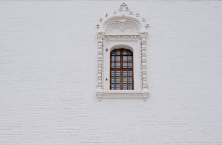 Carved window against a white wall. The territory of the Astrakhan Kremlin, the architecture of the Assumption Cathedral.の写真素材
