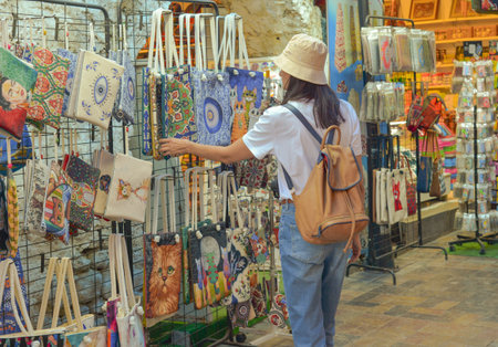 A young female tourist shops at a tourist market in Turkey looking for a bag or souvenir.