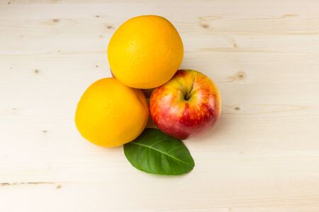 Apple and orange on a wooden boardの写真素材