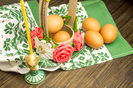 Easter russian still life. Eggs in a flower basket, sweets, rolls, prepared for rest on a wooden...