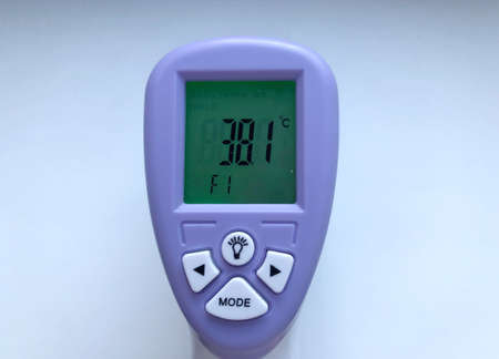Electronic thermometer in hand. A medical instrument, an electronic digital thermometer, is used to measure a patient's temperature in a hospital. Close-up, in hand thermometer on white background.の写真素材