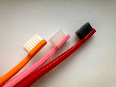 three multi-colored toothbrushes on a white backgroundの写真素材