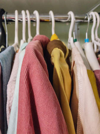 clothing for home. close-up, hands sorting clothes on hangers in a clothing store.の写真素材