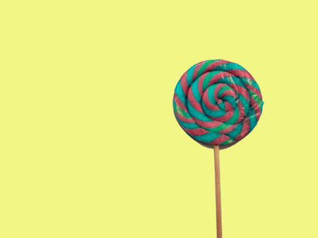 A large colored Lollipop isolated on a yellowの写真素材