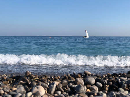 The blue sea and the waves. Yacht at sea. The boat sails on the sea on a clear Sunny dayの写真素材