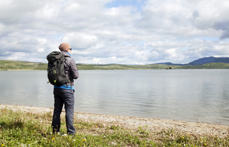 the traveler with a backpack at the lakeの写真素材