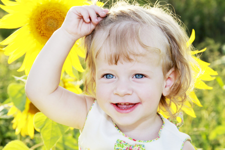 little girl laughing in a field of sunflowersの写真素材