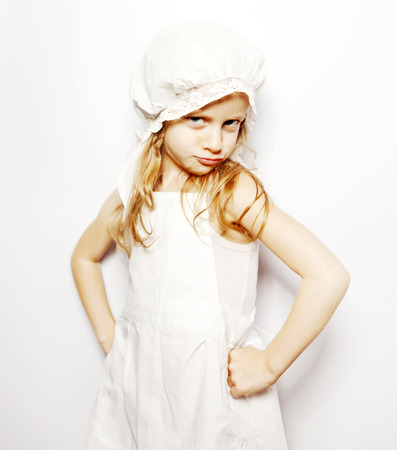 little girl hands on her hips in a white apron and capの写真素材