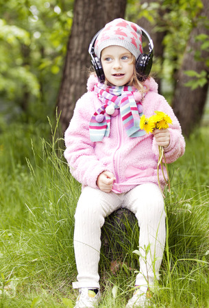 a little girl with yellow flowers and headphonesの写真素材