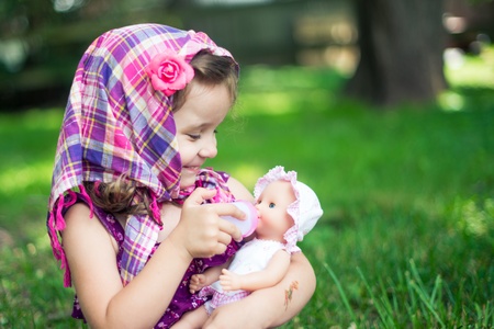Girl feeding her doll  portrat  の写真素材