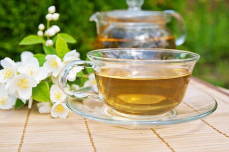 Cup of green tea with branch of jasmineの写真素材