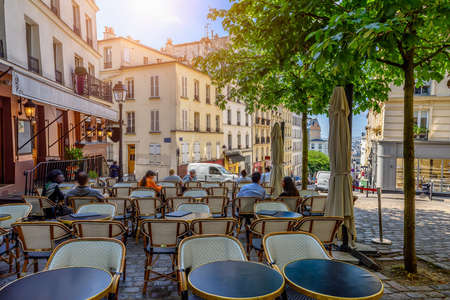 Cozy street with tables of cafe in quarter Montmartre in Paris, Franceの写真素材