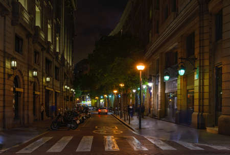 Cozy street with tables of bar in Barcelona, Catalonia, Spain. Architecture and landmark of Barcelona. Night cityscape of Barcelonaの写真素材