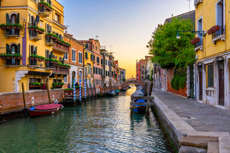 Narrow canal with gondola and bridge in Venice, Italy. Architecture and landmark of Venice. Cozy cityscape of Venice.の写真素材