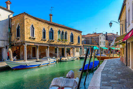 Canal with old buildings and boats in Murano island, Venice, Italy. Architecture and landmarks of Venice. Venice postcardの写真素材