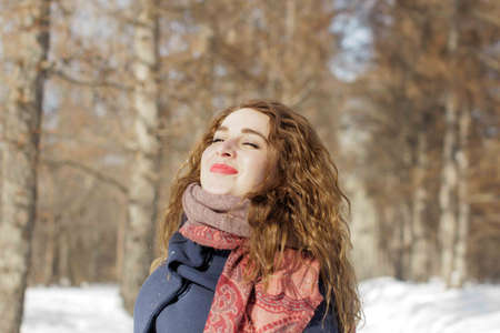 a woman in the park is happy about the coming winter