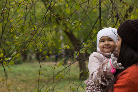 Mom with baby in autumn park. Autumn walk in the parkの写真素材