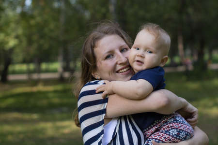 Portrait of happy loving mother and her baby in summer park