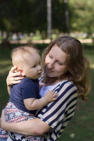 Portrait of happy loving mother and her baby in summer park