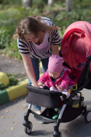 walk of a happy loving mother and her baby in a summer park