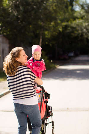 walk of a happy loving mother and her baby in a summer parkの写真素材