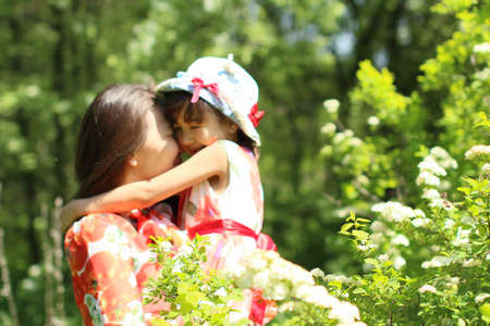 walk of a happy loving mother with her child in a summer park on a sunny afternoonの写真素材