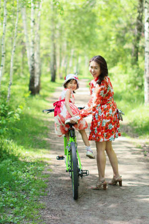 walk of a happy loving mother with her child in a summer park on a sunny afternoonの写真素材