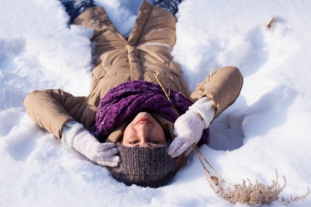 A contented Caucasian woman walks in a winter park. Young woman against a snow-covered park on a...