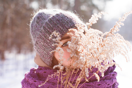 A contented Caucasian woman walks in a winter park. Young woman against a snow-covered park on a...
