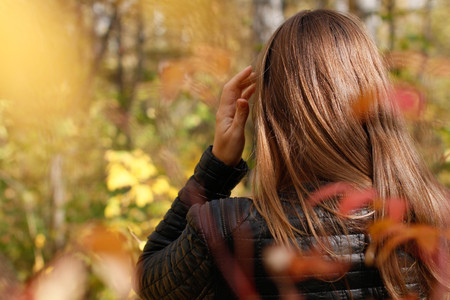 Portrait of a beautiful young woman on the background of the autumn landscape