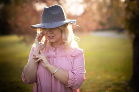 Young pretty blonde against the backdrop of an autumn park with evening light.