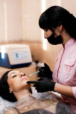 Russia, Novosibirsk, January 5, 2020. Woman lies with her eyes closed during the procedure in the beauty parlorのeditorial素材