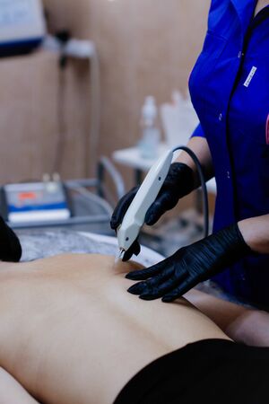 Russia, Novosibirsk, January 5, 2020. Woman lies with her eyes closed during the procedure in the beauty parlorのeditorial素材