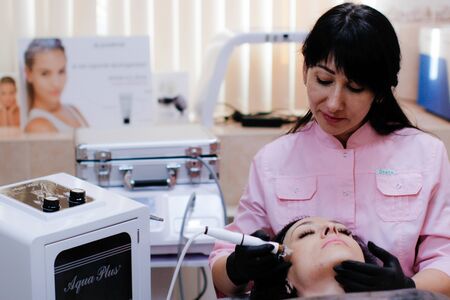Russia, Novosibirsk, January 5, 2020. Woman lies with her eyes closed during the procedure in the beauty parlorのeditorial素材