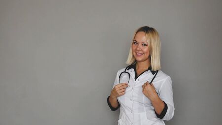 female doctor in a white medical coat on a gray background. healthcare conceptの写真素材