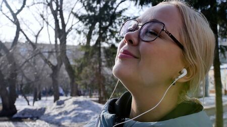 Portrait of a relaxed woman breathing deeply in a spring city park.