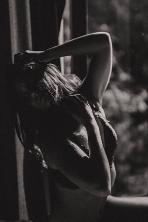 beautiful girl in tender feelings near the window with the bright morning light of the sunの写真素材